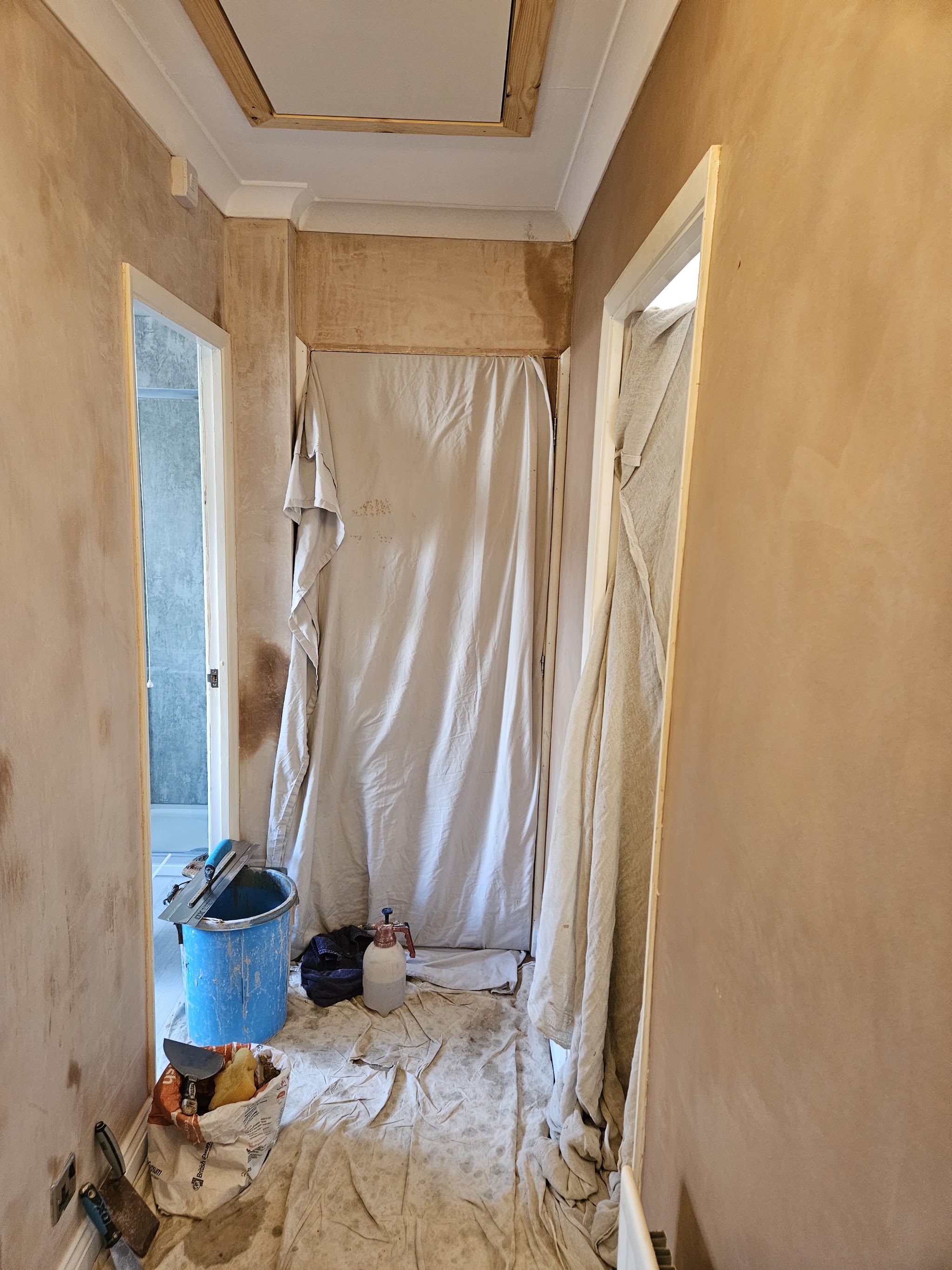 A hallway plastered and sheeted for the next stage